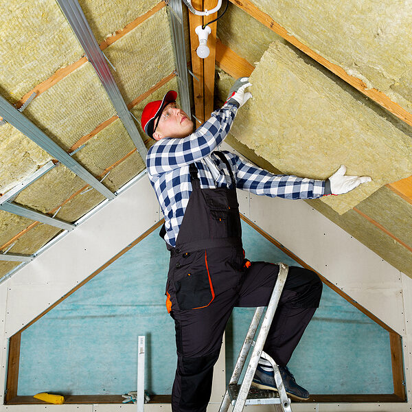 a man standing on a ladder in a room under construction