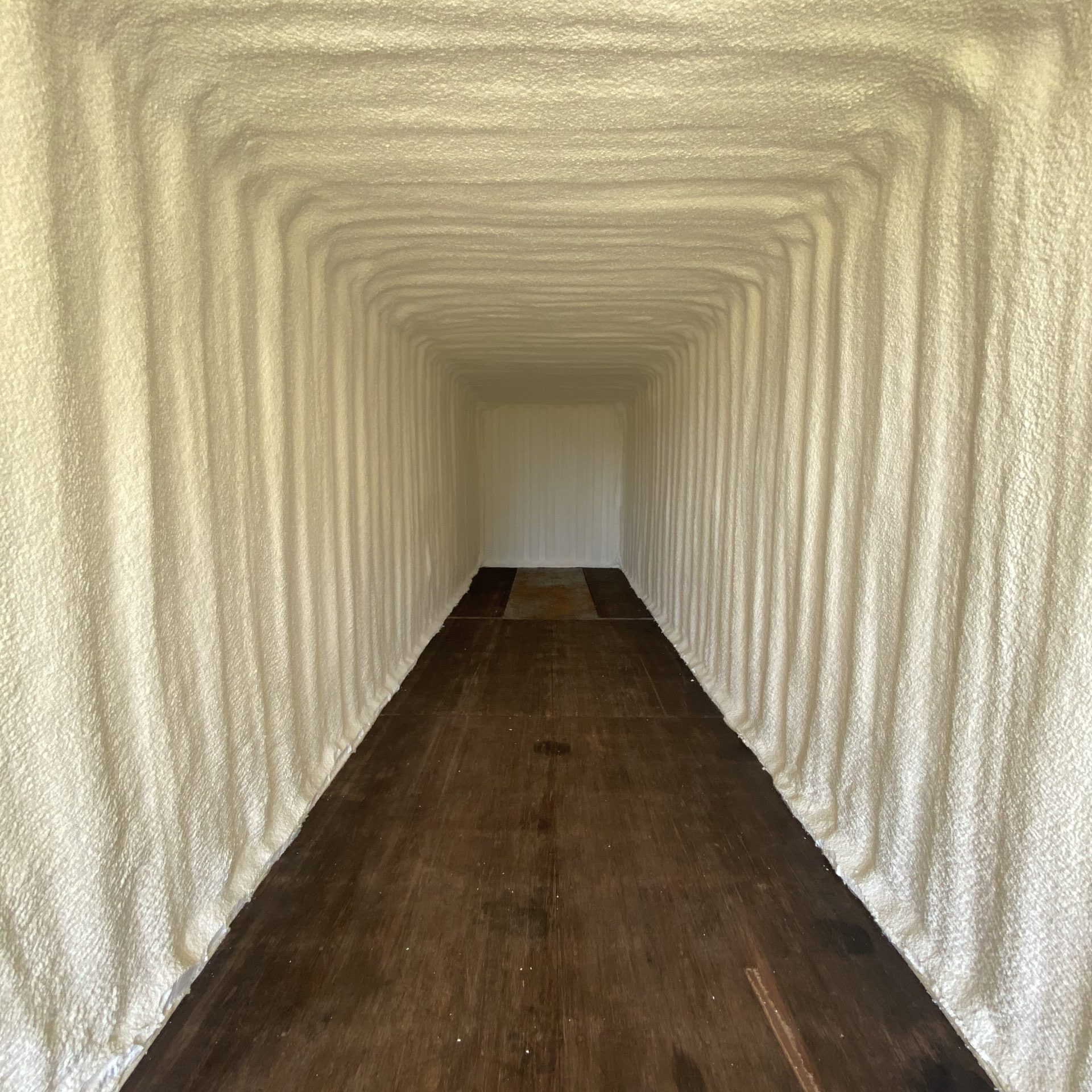 Hunt Brenham TX Insulate 1 a long narrow hallway with white walls and wood flooring